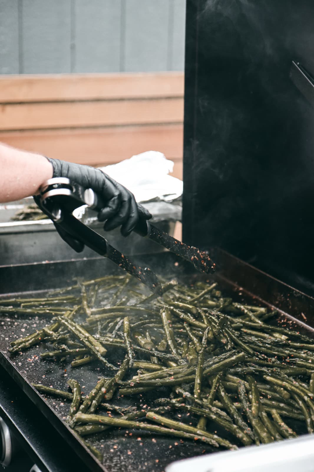 Chef grilling seasoned asparagus for a catered event